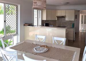 a kitchen with a table with white chairs and a counter at Isle of Palms 112 in Gold Coast