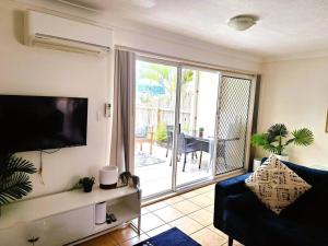 uma sala de estar com um sofá e uma grande porta de vidro deslizante em Isle of Palms 112 em Gold Coast