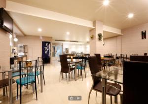 a dining room with tables and chairs in a restaurant at Hua Xiang Motel - Arena in Kaohsiung