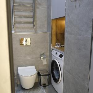 y baño pequeño con aseo y lavadora. en Iris Apartments B, en Tashkent