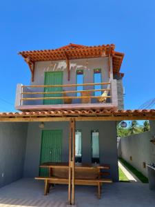 ein Haus mit einer Bank davor in der Unterkunft ((Casa brisa das águas)) Rota ecológica de milagres in Pôrto de Pedras
