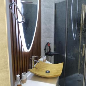 a bathroom with a wooden sink and a shower at Iris Apartments B in Tashkent +45 photos
