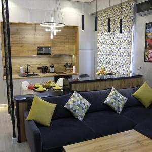 Una sala de estar con un sofá y una cocina. en Iris Apartments B, en Tashkent