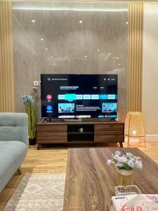 106 A شقة جميلة بغرفتين نوم ودخول ذاتي في الرياض: غرفة معيشة مع تلفزيون بشاشة مسطحة كبيرة