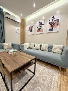106 A شقة جميلة بغرفتين نوم ودخول ذاتي في الرياض: غرفة معيشة مع أريكة زرقاء وطاولة