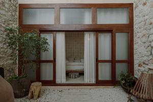 a room with a large glass door with a bed in the background at Hermosa casa junto a la muralla in Campeche +19 photos