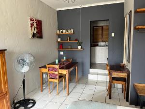 a dining room with a table and a fan at Green Hollow Self catering in Knysna