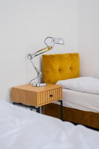 lampa na nocnym stoliku obok łóżka w obiekcie Torun Bridge Apartament w Toruniu