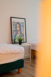 Un dormitorio con una cama y un escritorio con una pintura en Torun Bridge Apartament, en Toruń