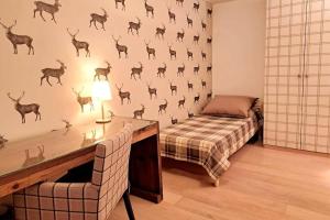 a bedroom with a bed and a wall with deer decals at Comfortable apartment near the ski station with parking in Laax