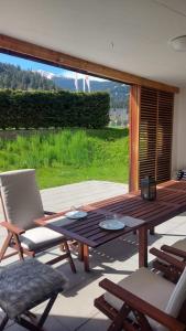 een terras met een tafel en stoelen bij Comfortable apartment near the ski station with parking in Laax