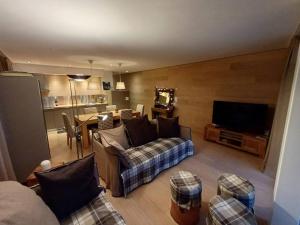 een woonkamer met een bank en een tv bij Comfortable apartment near the ski station with parking in Laax