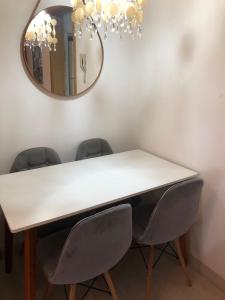 a dining room table with chairs and a mirror at APTO PRIME 2 DORM COM GARAGEM À 2,9km DA FENAC in Novo Hamburgo
