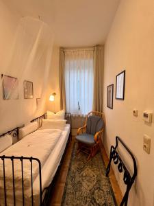 1 dormitorio con 1 cama, 1 silla y 1 ventana en Apartment Blick ins Grüne en Bamberg