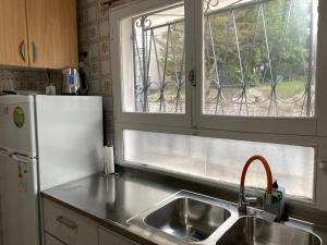 a kitchen with a sink and a refrigerator and a window at Departamento centrico in Ushuaia