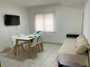 a bedroom with a table and chairs and a bed at Departamento centrico in Ushuaia