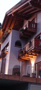 een huis met balkons en bloemen aan de zijkant bij Hotel Garni Civetta in Selva di Cadore