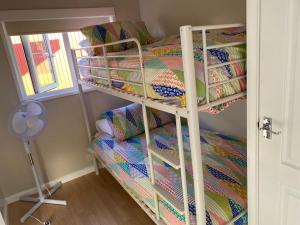 a bunk bed in a room with a bed at The Chalet in Stalham +1 photo