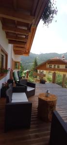 a patio with couches and a table and a building at Hotel Garni Civetta in Selva di Cadore