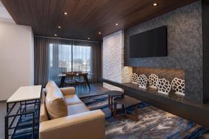 uma sala de estar com um sofá e uma televisão na parede em Fairfield by Marriott Inn & Suites Hillsboro em Hillsboro