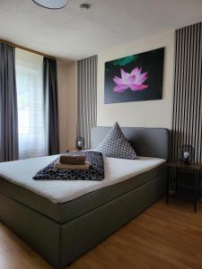 ein Schlafzimmer mit einem großen Bett mit einer rosa Blume an der Wand in der Unterkunft Pension Restaurant Luna in Treis-Karden