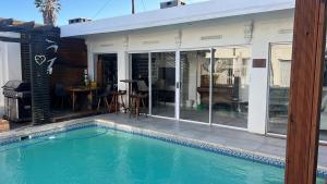a swimming pool in front of a house at Apartment on 32 in Cape Town