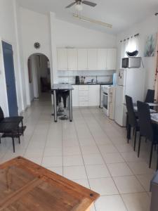 a kitchen with white cabinets and a table and chairs at 1 bedroom in Regina Gardes 2 in Paphos City