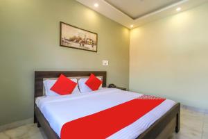 a bedroom with a large bed with red pillows at Summer Palms in Kangra