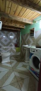 a bathroom with a toilet and a washing machine at LAPOSTa555 in Piriápolis