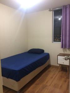 1 dormitorio con cama con sábanas azules y ventana en Bonito departamento VIP estreno en Condominio, en Lima