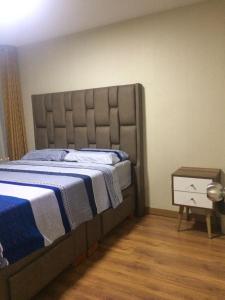 1 dormitorio con 1 cama y mesita de noche al lado en Bonito departamento VIP estreno en Condominio, en Lima