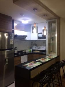 eine Küche mit einer Theke mit Stühlen und einem Kühlschrank in der Unterkunft Bonito departamento VIP estreno en Condominio in Lima