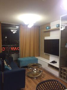 sala de estar con sofá azul y TV en Bonito departamento VIP estreno en Condominio, en Lima