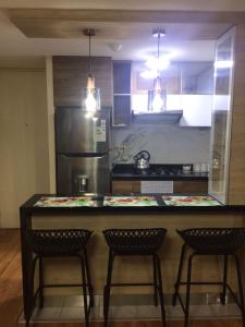 a kitchen with a counter with three chairs and a counter top at Departamento VIP estreno en Condominio in Lima +11 photos