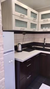 a kitchen with a white refrigerator and black cabinets at APARTAMENT SŁUPSK in Słupsk