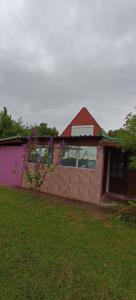 ein Haus mit einem roten Dach und einem grünen Hof in der Unterkunft LAPOSTa555 in Piriápolis