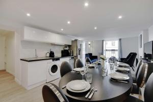 a dining room with a table and chairs and a kitchen at CMG - Residence OpéraGrands Magasins in Paris