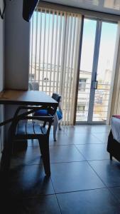 a living room with a table and a couch andwindows at Hotel Monarka-Edificio in Popayan