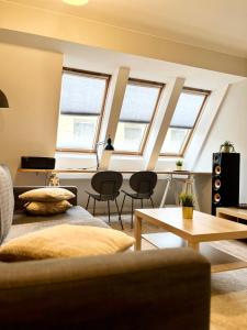 salon z oknami, kanapą i stołami w obiekcie Wąska 5 Apartamenty we Wrocławiu