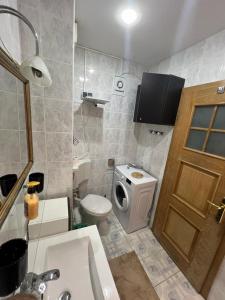 uma casa de banho com um WC, um lavatório e uma porta em Apartament Marcus 1 Poiana Brasov em Poiana Brasov