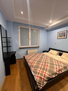 um quarto com uma cama com um cobertor xadrez em Apartament Marcus 1 Poiana Brasov em Poiana Brasov