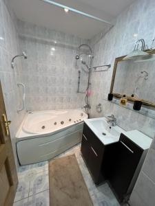 uma casa de banho com uma banheira e um lavatório em Apartament Marcus 1 Poiana Brasov em Poiana Brasov