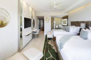 a hotel room with two beds and a tv at Residential Retreat 3 Bedroom Suite Ocean Front Garza Blanca Los Cabos Resort & Spa in Cabo San Lucas