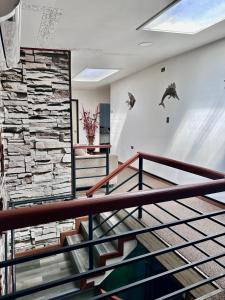 a lobby with stairs and a stone wall at Hostal Umantun in Dalcahue