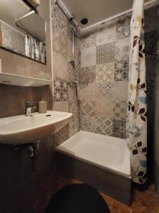 a bathroom with a sink and a tub and a shower at Pension Restaurant Luna in Treis-Karden