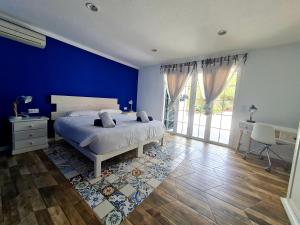 1 dormitorio con 1 cama con pared azul en Galdana's House, en Cala Galdana