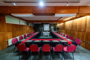 una sala de conferencias con una mesa larga y sillas rojas en HOTEL NOMADES PATAGONIA, en Coyhaique