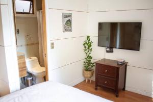 1 dormitorio con TV de pantalla plana en la pared en Casa Ñilhue, Camino a la Farellones en Santiago
