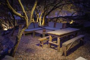 ein Picknicktisch und Bänke neben einem Baum in der Unterkunft Casa Ñilhue, Camino a la Farellones in Santiago