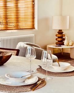 una mesa con platos y copas de vino. en luxe appartement op topligging, en Knokke-Heist